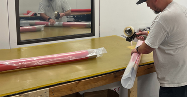 Pacific Coast Composites employee cutting and preparing composite material.   