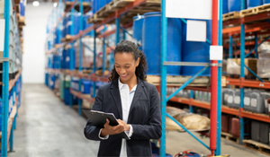 Procurement specialist reviewing aerospace material near warehouse shelves storing specialty chemicals.  